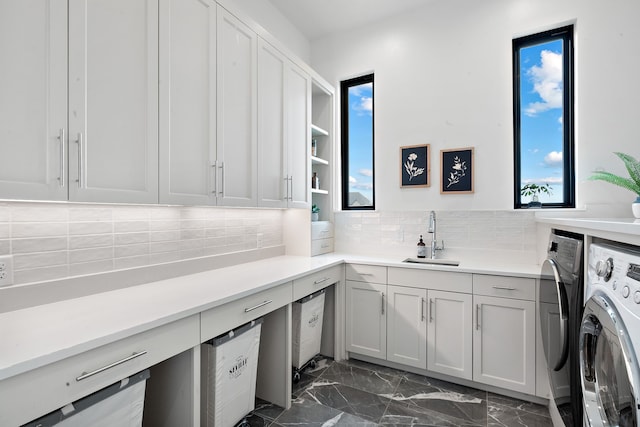 laundry room with a sink, cabinet space, marble finish floor, and washer and clothes dryer