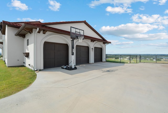 garage featuring a gate, fence, and driveway