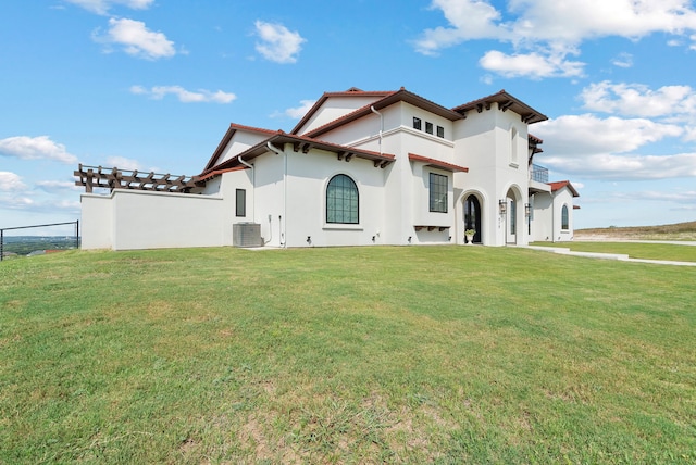 exterior space with a front lawn, a tile roof, central AC, and stucco siding