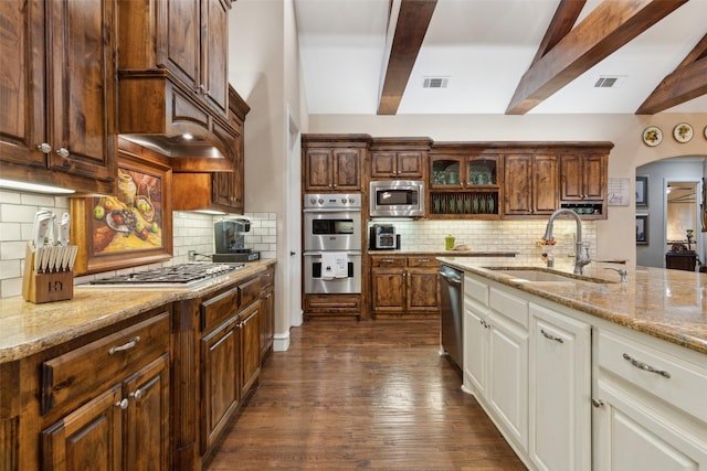 kitchen with a sink, arched walkways, visible vents, and stainless steel appliances