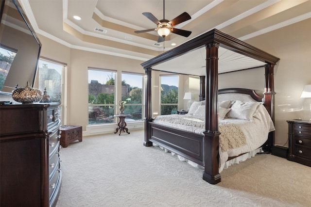 carpeted bedroom featuring visible vents, crown molding, a raised ceiling, and ceiling fan