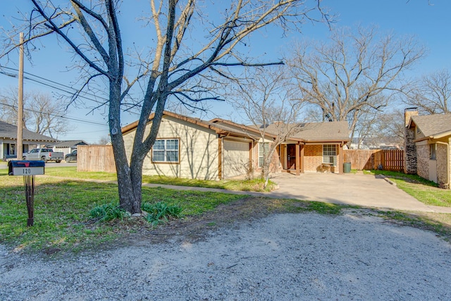 view of front facade with brick siding, driveway, a garage, and fence