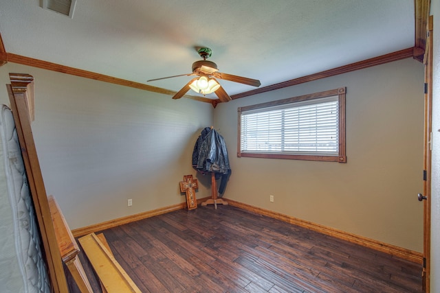 spare room featuring visible vents, baseboards, dark wood-style floors, and ornamental molding