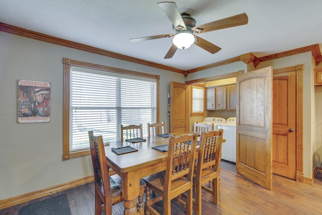 dining space featuring crown molding, baseboards, washer and clothes dryer, light wood-style floors, and a textured ceiling