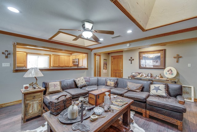 living room with visible vents, wood-type flooring, baseboards, and crown molding