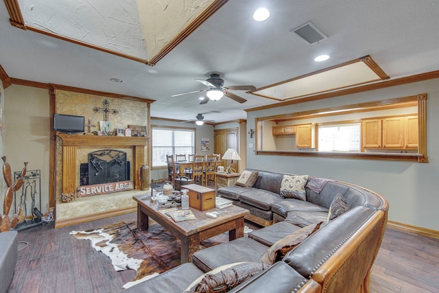 living area featuring visible vents, hardwood / wood-style floors, and ornamental molding