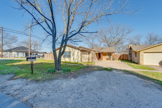 view of front of house with a front lawn, driveway, fence, a garage, and brick siding