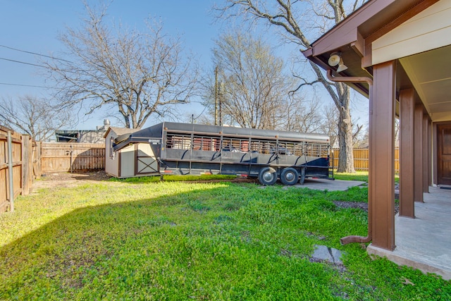 view of yard featuring an outbuilding, a shed, and a fenced backyard