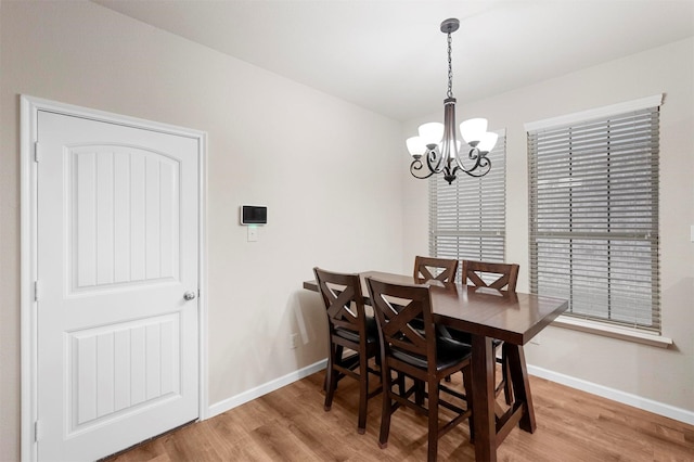 dining room featuring baseboards, a notable chandelier, and wood finished floors