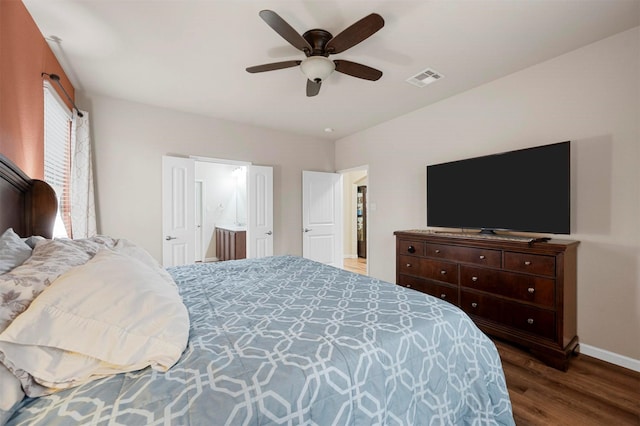 bedroom with wood finished floors, visible vents, baseboards, ceiling fan, and connected bathroom