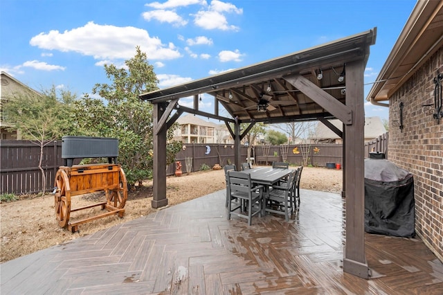 view of patio featuring a gazebo, a grill, outdoor dining area, and a fenced backyard