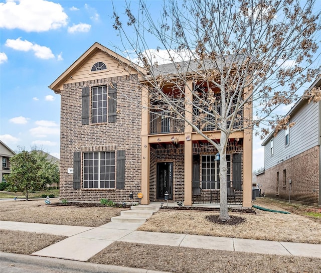 traditional home with brick siding, central air condition unit, and a balcony