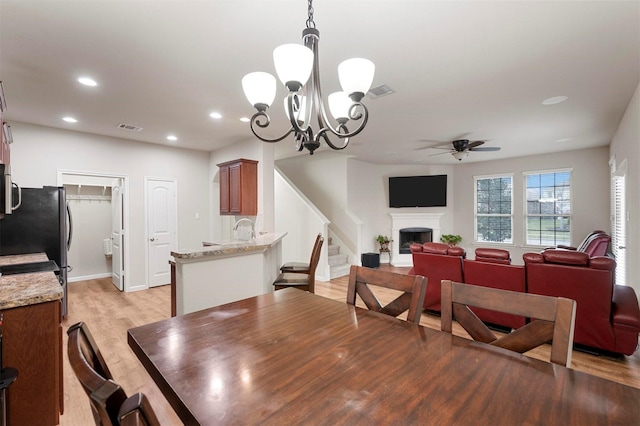 dining space featuring visible vents, stairway, recessed lighting, a fireplace, and light wood-style floors