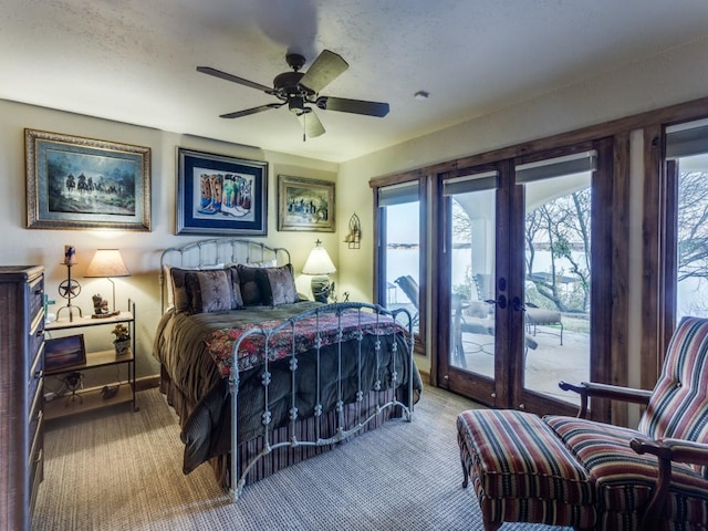 carpeted bedroom featuring access to exterior, multiple windows, a ceiling fan, and baseboards