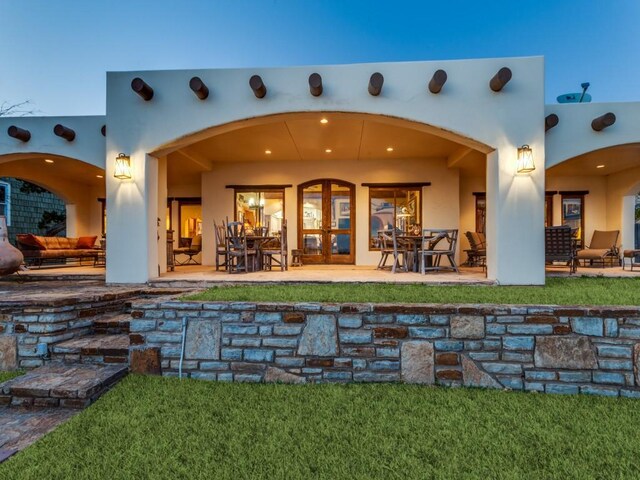 rear view of house featuring stucco siding and a patio