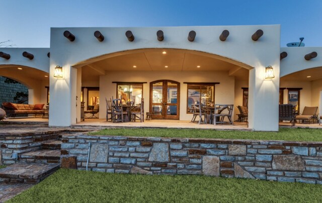 rear view of property featuring a patio and stucco siding