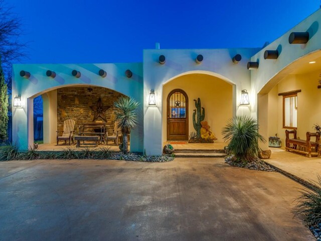 doorway to property featuring stucco siding