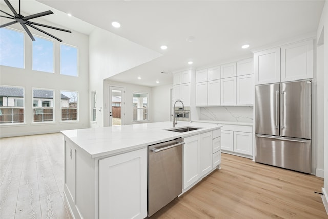 kitchen featuring a wealth of natural light, a kitchen island with sink, appliances with stainless steel finishes, and a sink