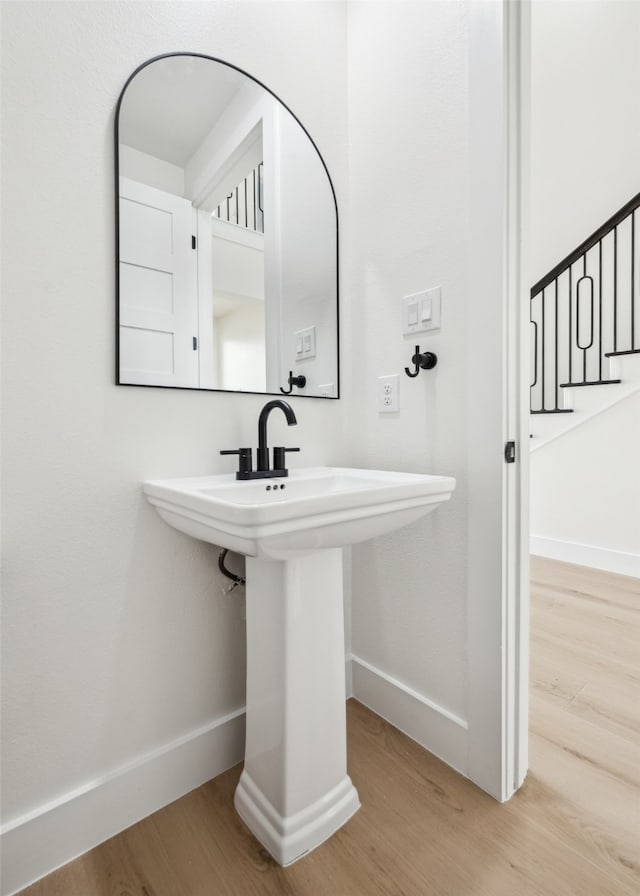 bathroom featuring a sink, baseboards, and wood finished floors