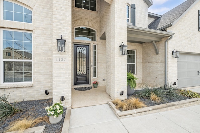 property entrance with brick siding and a garage