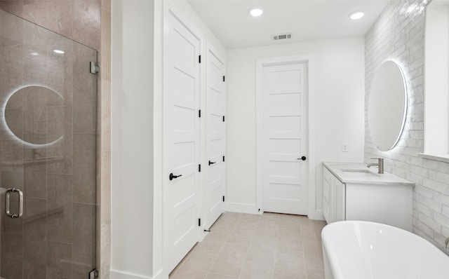 full bathroom with visible vents, a shower stall, a freestanding bath, and vanity