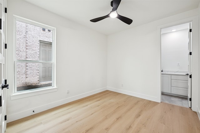 spare room featuring baseboards, light wood-style floors, and ceiling fan