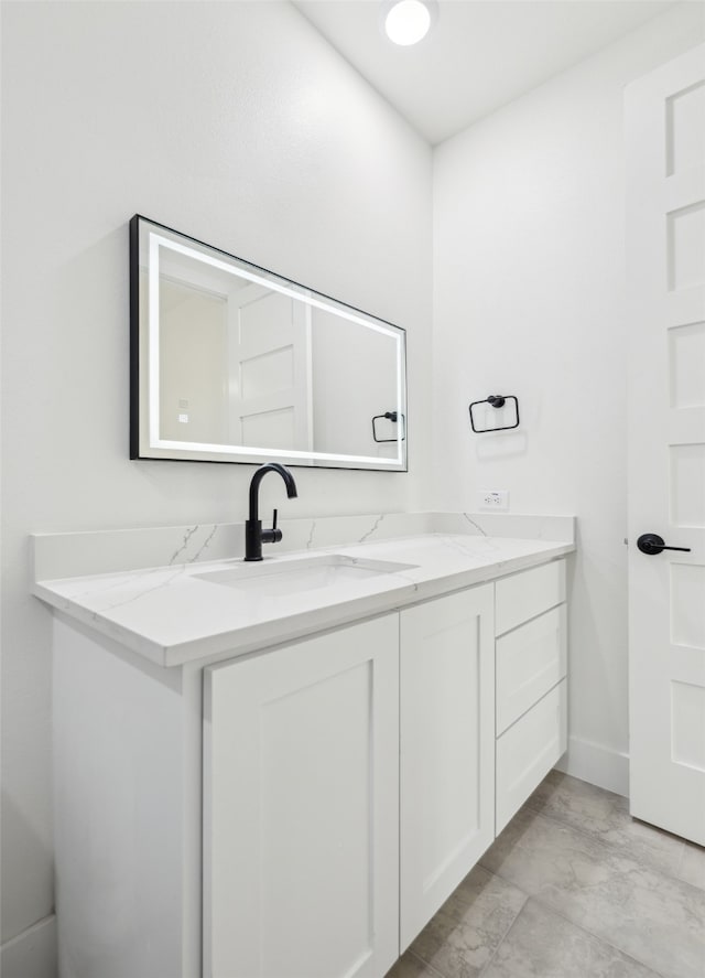 bathroom with vanity, baseboards, and marble finish floor