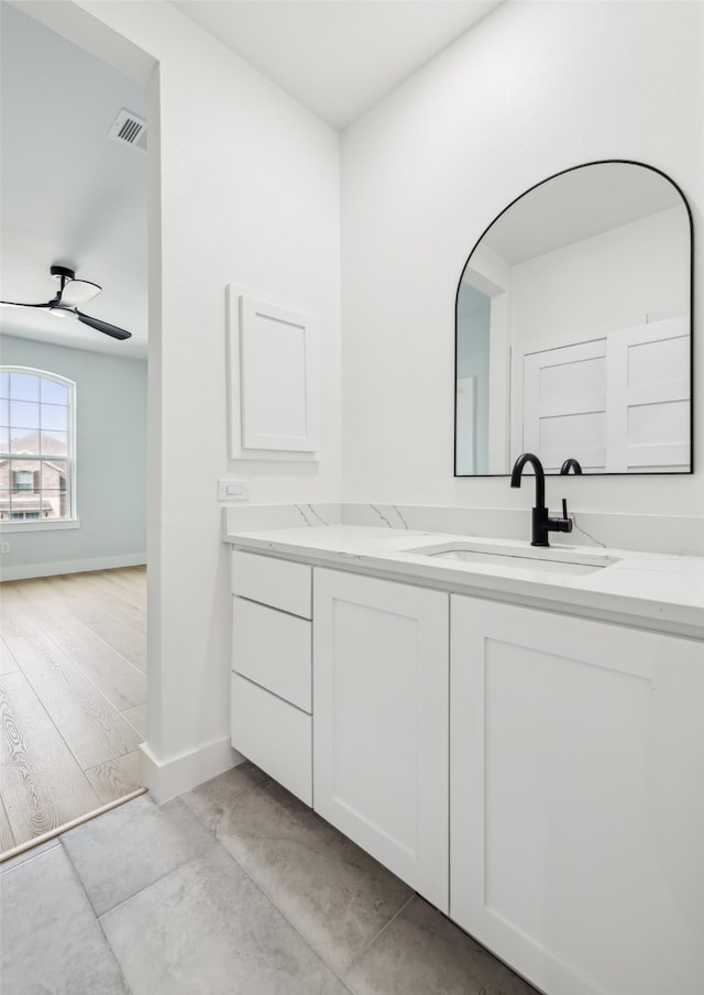 bathroom with vanity, wood finished floors, visible vents, and baseboards