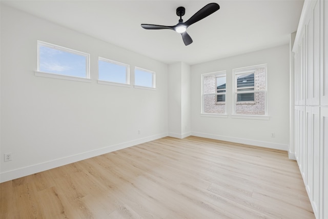 unfurnished room with light wood finished floors, ceiling fan, and baseboards