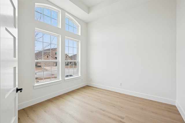 empty room featuring light wood-type flooring and baseboards