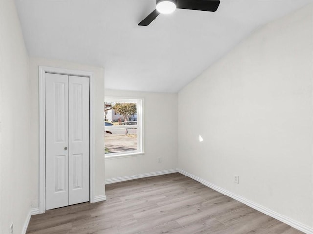 unfurnished bedroom with ceiling fan, wood finished floors, a closet, and baseboards