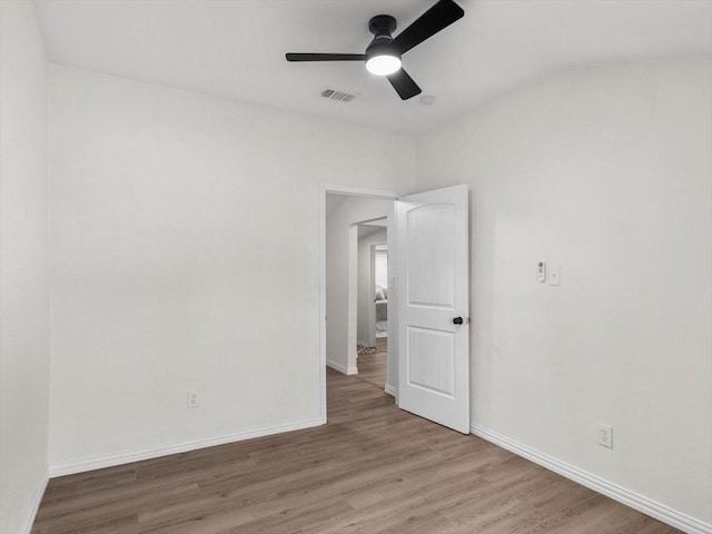 unfurnished room featuring light wood finished floors, visible vents, ceiling fan, and baseboards