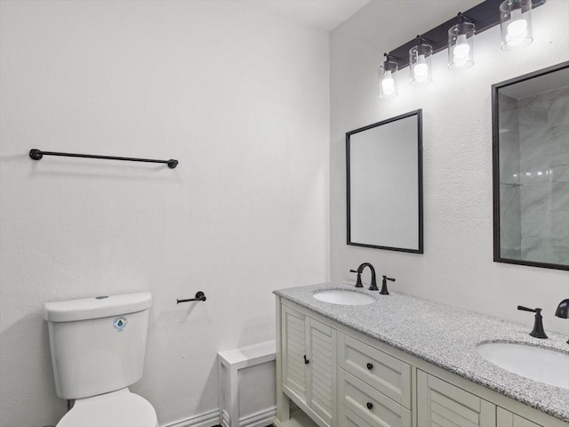 full bathroom with double vanity, toilet, and a sink