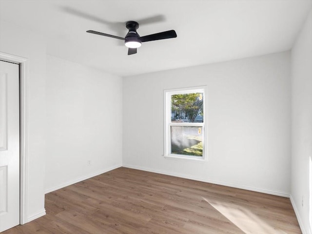 unfurnished room featuring ceiling fan, baseboards, and wood finished floors