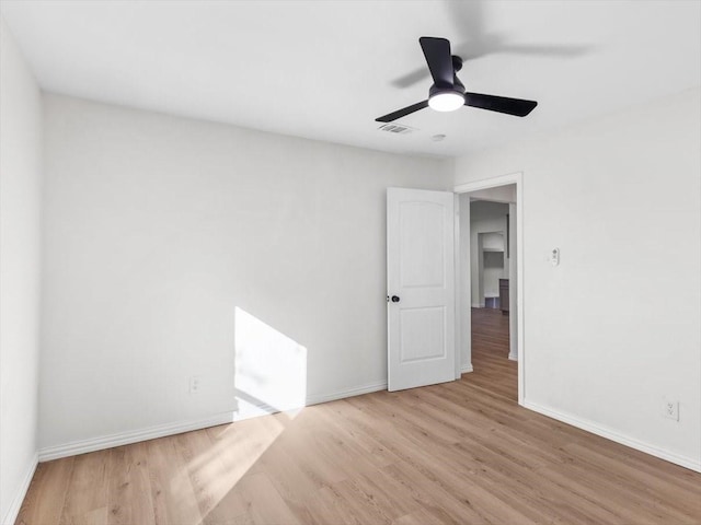 spare room with baseboards, visible vents, light wood finished floors, and ceiling fan