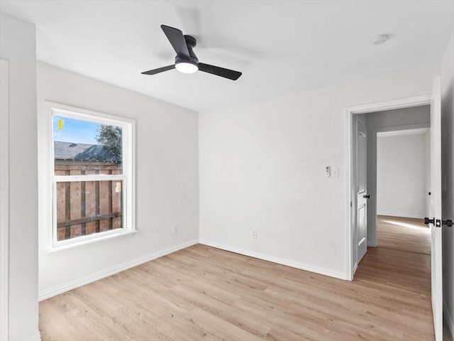 empty room with baseboards, light wood-style floors, and ceiling fan