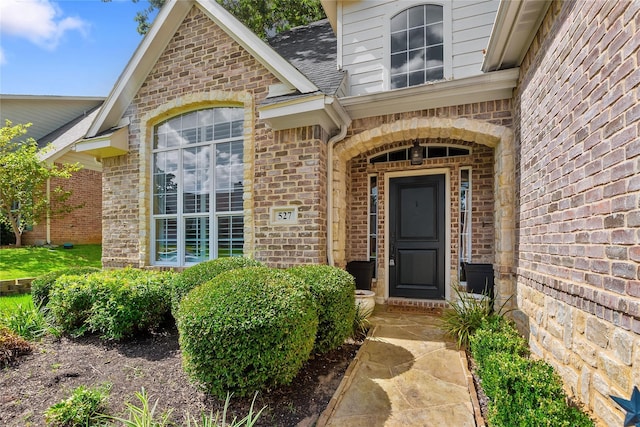 view of exterior entry featuring brick siding