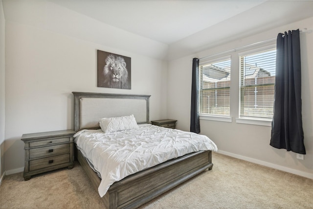 bedroom with baseboards and light carpet