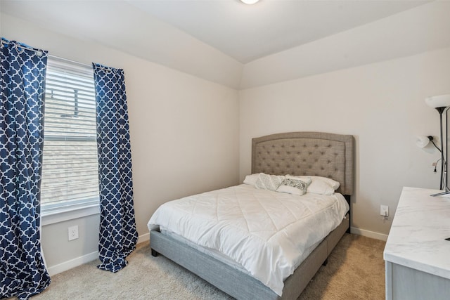 bedroom with light colored carpet and baseboards