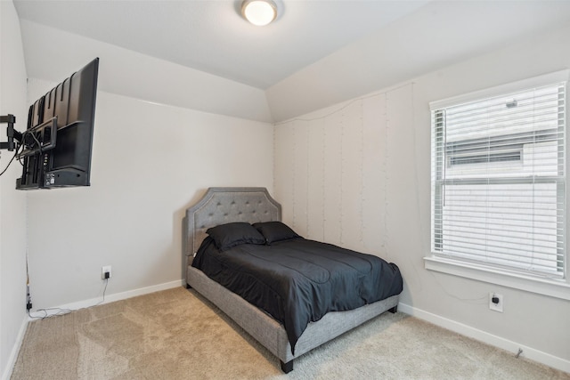 bedroom with vaulted ceiling, baseboards, and carpet floors