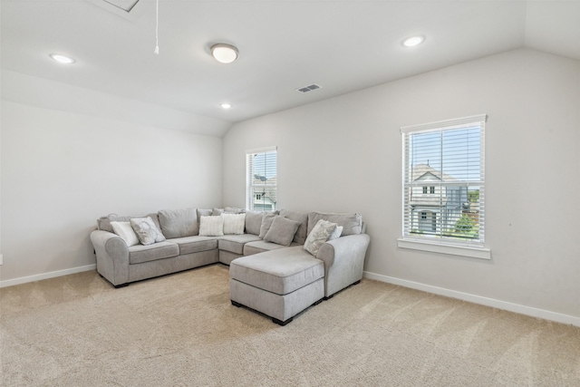 living area featuring visible vents, baseboards, attic access, lofted ceiling, and carpet flooring