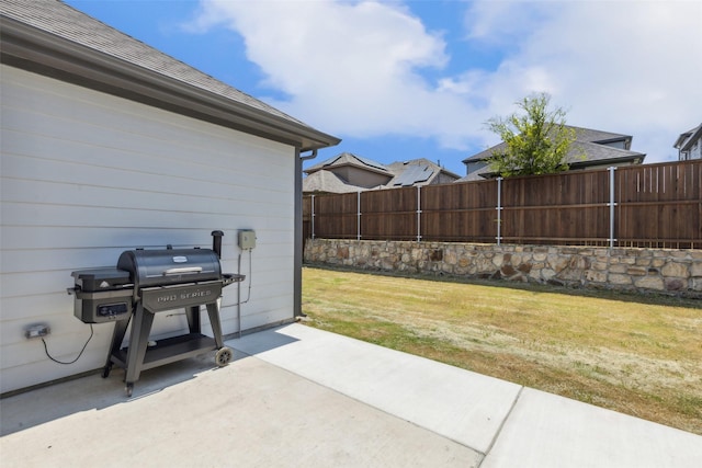 view of patio with area for grilling and fence