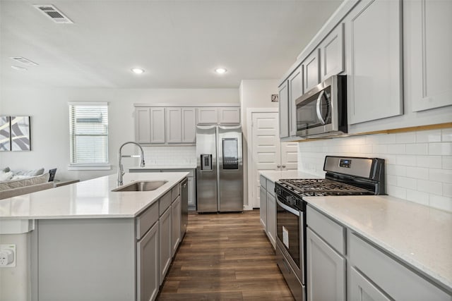 kitchen featuring dark wood-style floors, visible vents, gray cabinets, a sink, and appliances with stainless steel finishes