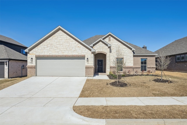 french country style house featuring a garage, brick siding, roof with shingles, and driveway