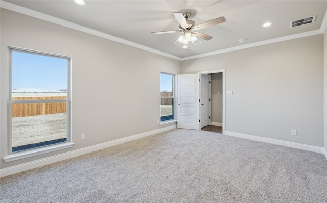 unfurnished room with a ceiling fan, baseboards, visible vents, crown molding, and carpet flooring