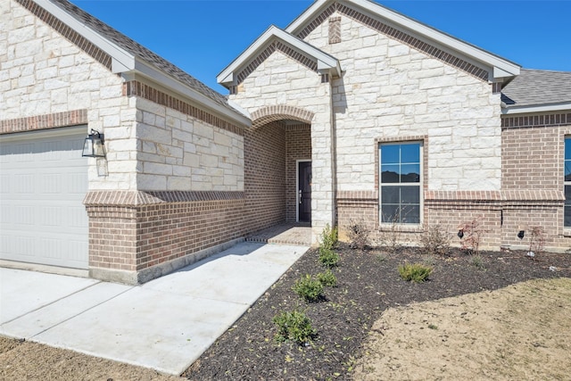 view of front of home featuring stone siding, brick siding, an attached garage, and a shingled roof