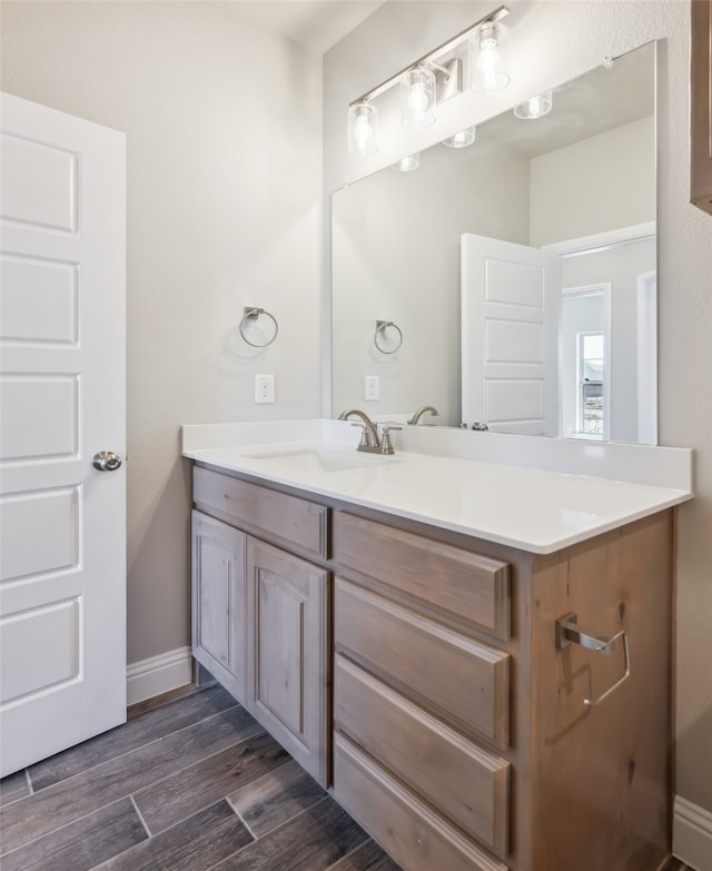 bathroom with vanity, baseboards, and wood finished floors