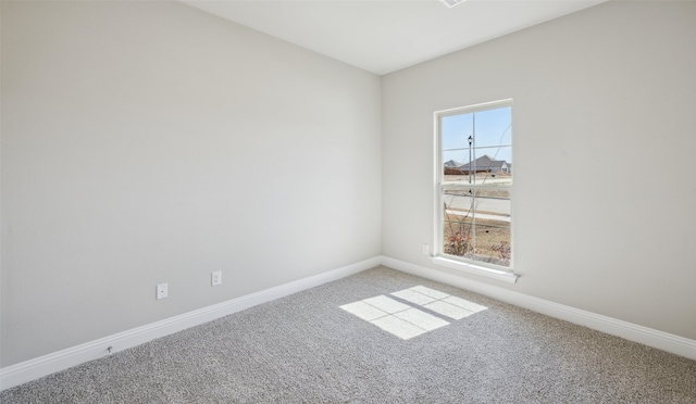 unfurnished room with baseboards and carpet