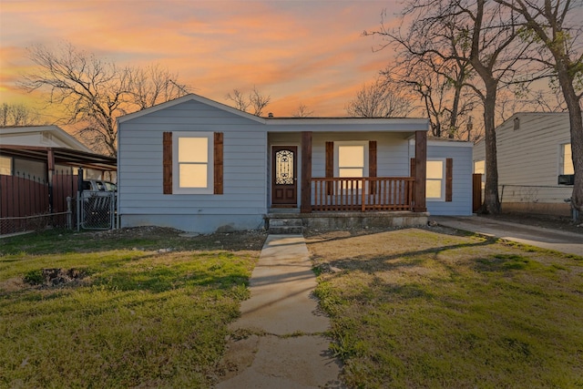 view of front of home featuring a porch, a gate, a yard, and fence