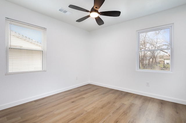 spare room featuring visible vents, a healthy amount of sunlight, and baseboards